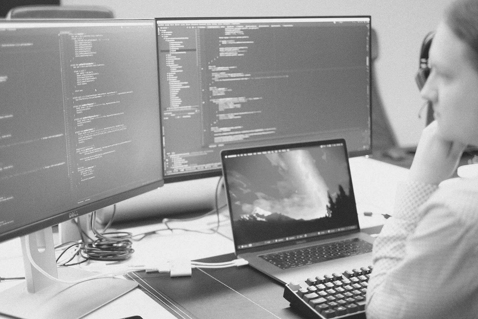 Devize utveckling och teknik - Systemutvecklare skriver kod framför bildskärmar