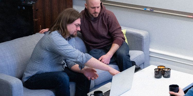 Medarbetare på Devize tittar på en laptop och pekar på skärmen